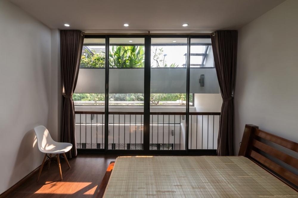 Không gian ngủ nghỉ được thiết kế, bài trí đơn giản với khung cửa sổ lớn và cây xanh mát mắt. không gian nhà đẹp