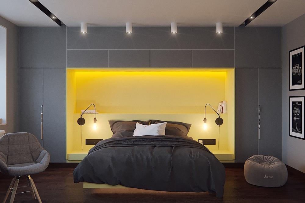 Màu vàng tại khu vực đầu giường đã tạo điểm nhấn hài hòa trên mảng tường xám,  ​tăng thêm chiều sâu cho phòng ngủ