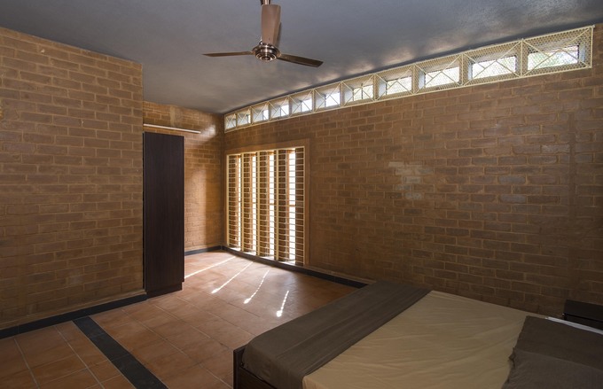 Phòng ngủ đơn giản với nội thất có tông màu phù hợp với tường làm từ gạch bùn