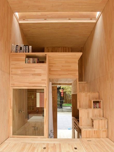 Nhìn tòa nhà như một công trình gỗ nguyên khối đầy tinh tế, ở đây có cả cầu thang, khoảng gầm tạo ra các khe trống được tận dụng để sách và băng đĩa