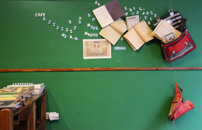 tường quán trang trí những chiếc cặp sách, tập vở cũ