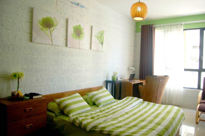 Bộ drap giường và những bức tranh treo tường được phối theo tông màu xanh lá Bộ drap giường và những bức tranh treo tường cũng màu xanh lá