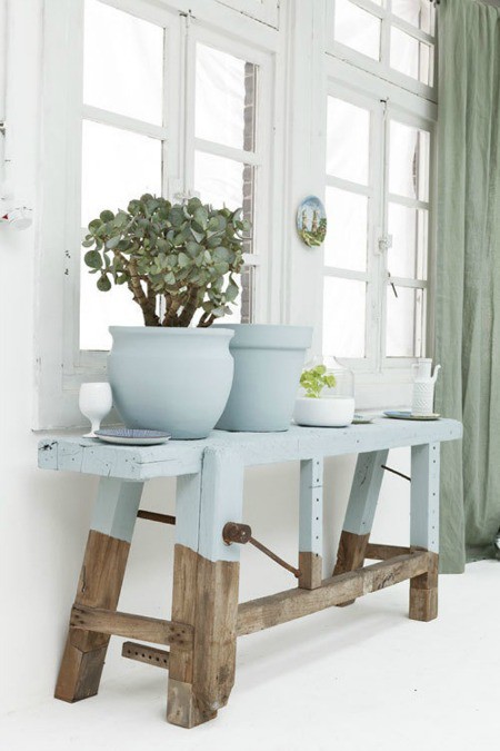 Chiếc ghế gỗ và chậu hoa sơn màu xanh pastel hài hòa với khung cửa sổ trắng tinh