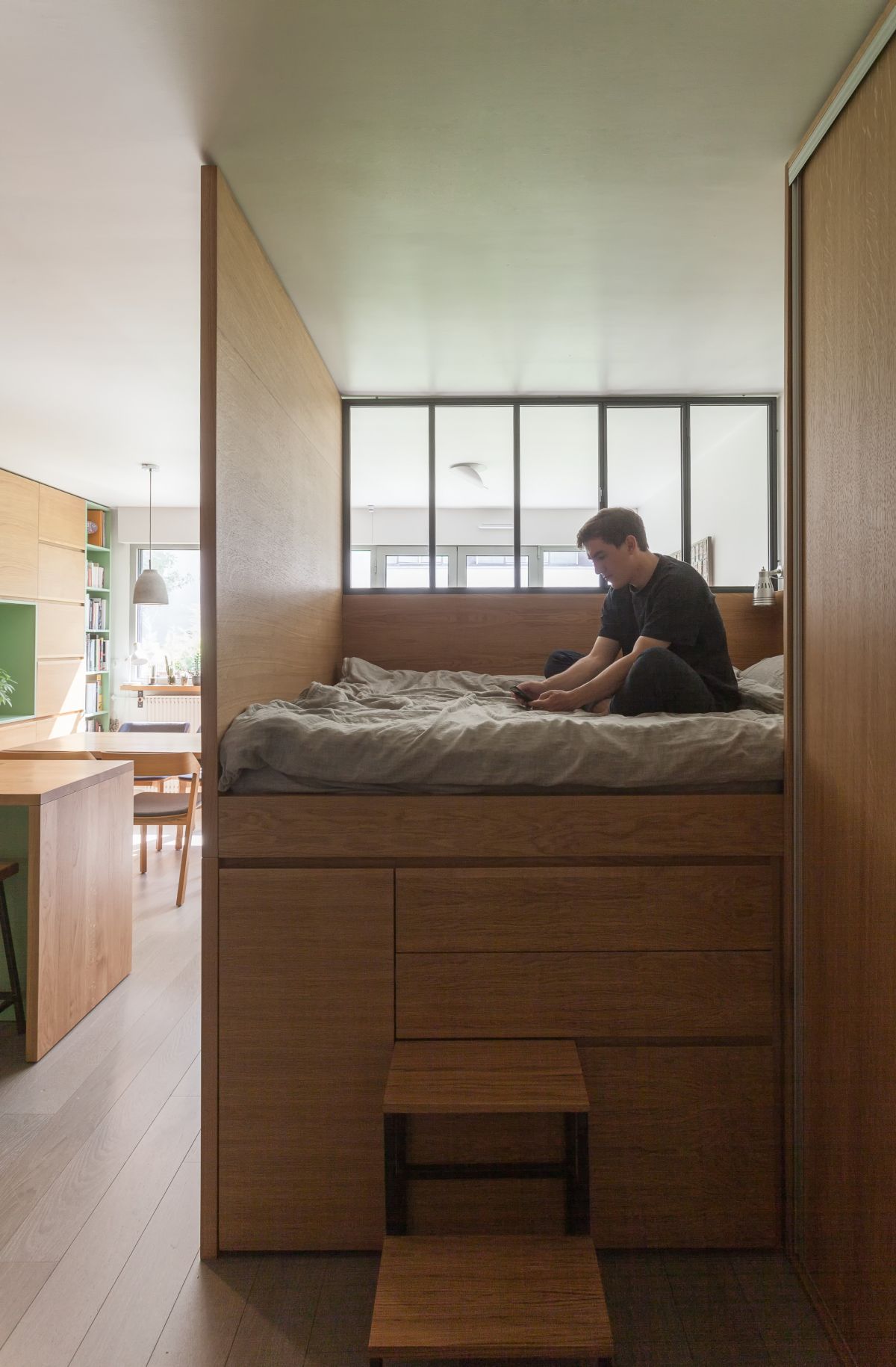 Bên trên khu kệ tủ lưu trữ đồ là giường ngủ được thiết kế thông minh, "đo ni đóng giầy" cho căn hộ