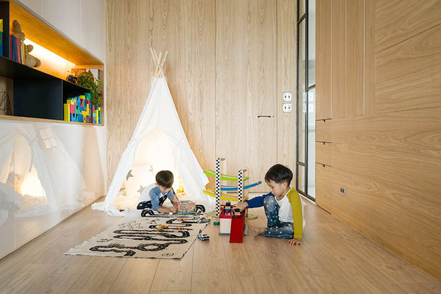 Chất liệu gỗ thân thiện với trẻ nhỏ nên được sử dụng nhiều trong phòng chơi của các bé. Khu vực này còn được tận dụng thành nơi đặt hệ tủ âm tường nhằm gia tăng không gian lưu trưc đồ đạc cho căn hộ nhỏ. 